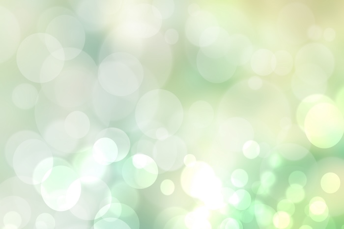 Abstract blurred fresh vivid spring summer light delicate pastel yellow green white bokeh background texture with bright circular soft color lights. Beautiful backdrop illustration.